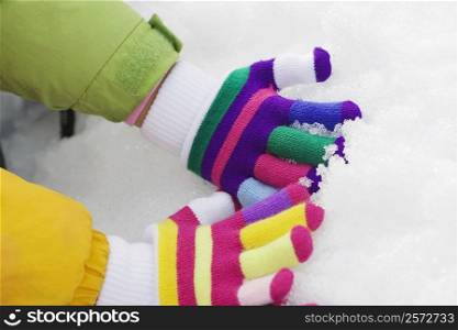 Two people hand&acute;s playing with snow