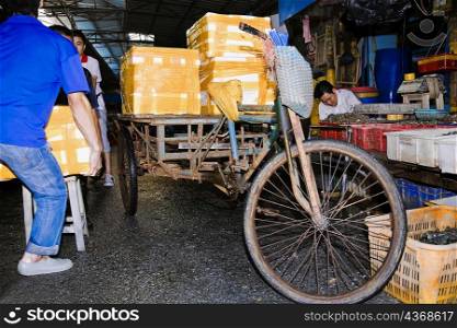 Two people loading package into a cart, Shamian Island, Guangzhou, Guangdong Province, China
