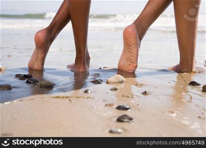 Two people on beach with crossed legs