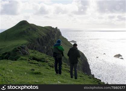 Two people on Mykines. Two people on top of the cliffs of Mykines on the Faroe Islands