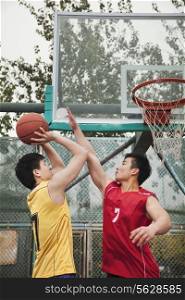 Two people playing basket ball