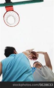 Two people playing basketball, blocking