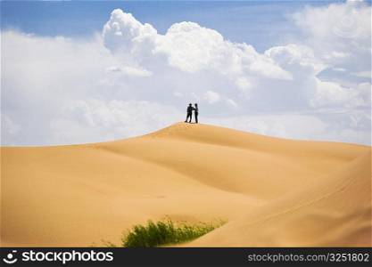 Two people standing on a sand dune, Kubuqi Desert, Inner Mongolia, China