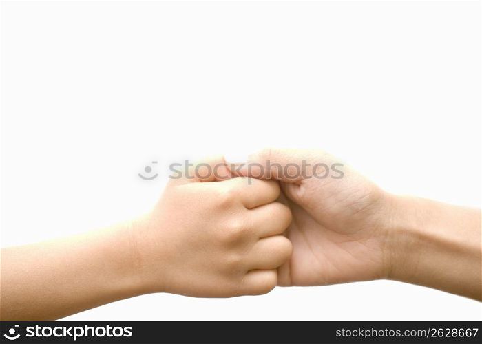 Two peoples hands gripped together against a white background