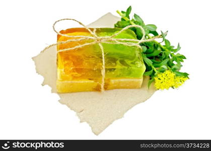 Two pieces of homemade soap, tied with twine with Rhodiola rosea flowers on a piece of paper isolated on white background