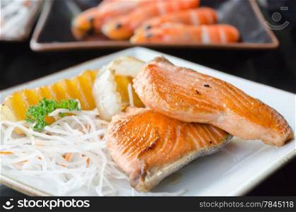 two pieces of salmon steak with vegetable on dish