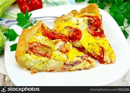 Two pieces pie of zucchini with tomatoes and eggs in a plate on a napkin, parsley on a wooden boards background