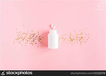 Two pills, white bottle and gold stars confetti on pink background. Concept Insomnia and sleep problems. Top view Flat lay Copy space.. Two pills, white bottle and gold stars confetti on pink background. Concept Insomnia and sleep problems. Top view Flat lay Copy space