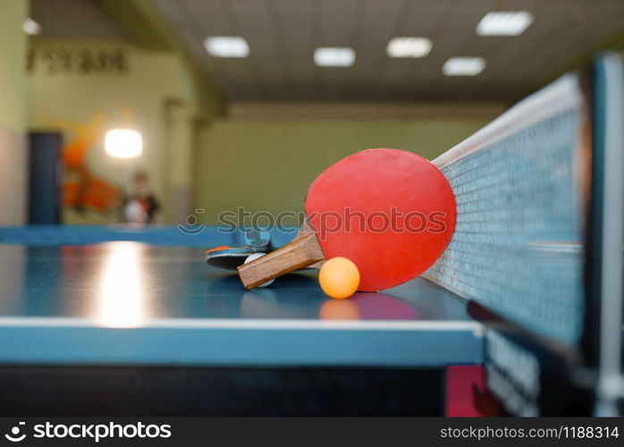 Two ping pong rackets and ball on the table with net, nobody, closeup view. Table-tennis club, tennis concept, ping-pong