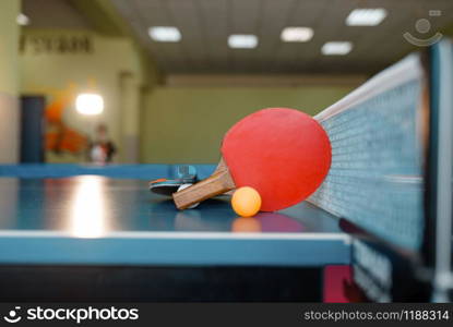 Two ping pong rackets and ball on the table with net, nobody, closeup view. Table-tennis club, tennis concept, ping-pong