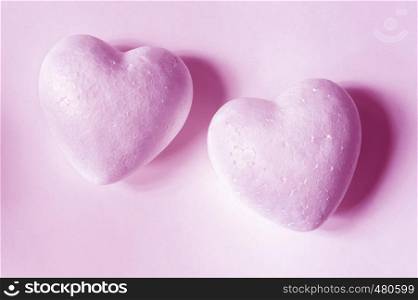 two pink hearts of styrofoam on paper background