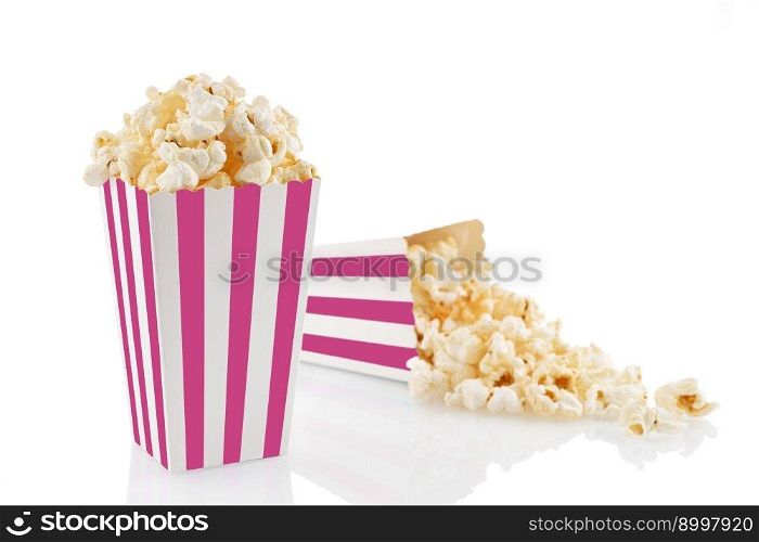 Two pink white striped carton buckets with tasty cheese popcorn, isolated on white background. Box with scattering of popcorn grains. Movies, cinema and entertainment concept.