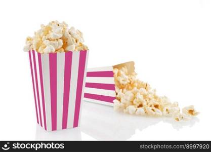 Two pink white striped carton buckets with tasty cheese popcorn, isolated on white background. Box with scattering of popcorn grains. Movies, cinema and entertainment concept.