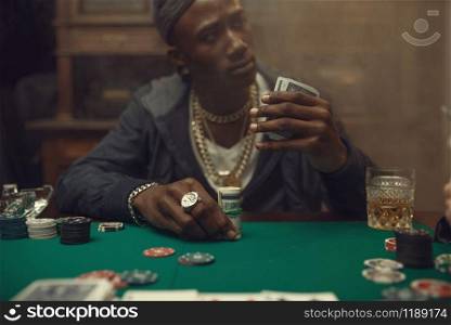 Two poker players place bets on gaming table with green cloth in casino. Games of chance addiction, risk, gambling house. Men leisures with whiskey and cigars. Two poker players place bets in casino