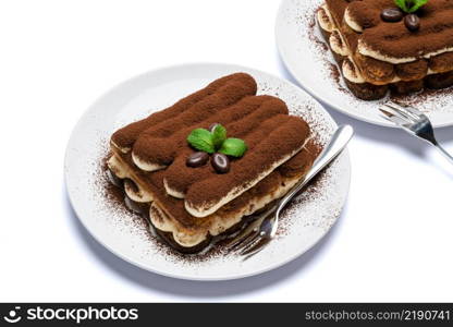 Two portions of Classic tiramisu dessert on ceramic plate isolated on white background with clipping path embedded. Two portions of Classic tiramisu dessert on ceramic plate isolated on white background with clipping path