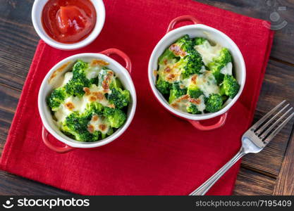 Two pots with baked broccoli and cheese