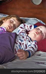 Two precious children sleeping on Christmas Eve, dreaming about Santa Claus.