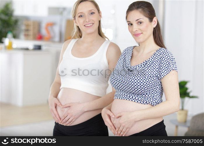 two pregnant women looking at camera