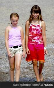 Two preteen girls walking on a beach