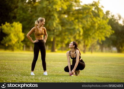 Two pretty retty young woman doing stretching in the park