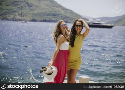 Two pretty young women having fun by the sea on a summer day