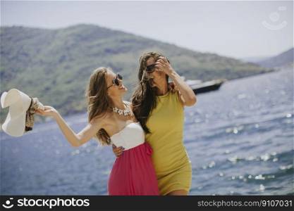 Two pretty young women having fun by the sea on a summer day