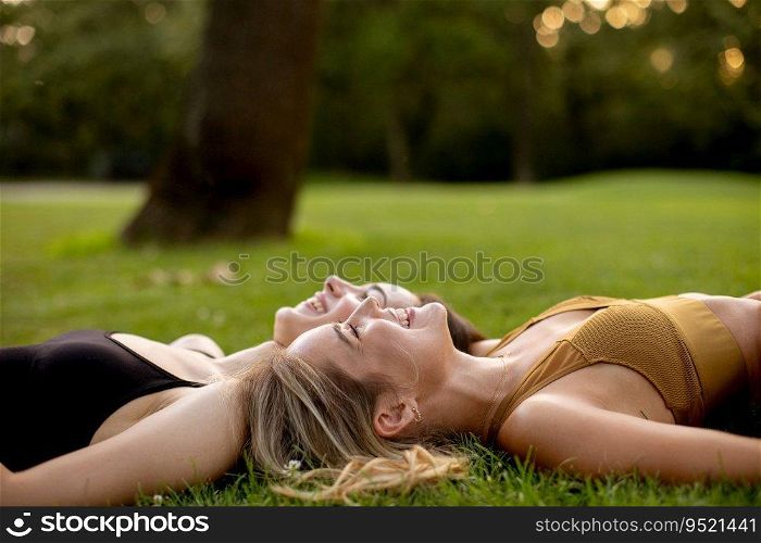 Two pretty young women laying on the grass
