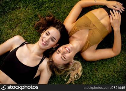 Two pretty young women laying on the grass