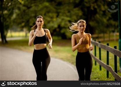 Two pretty young women running in the park