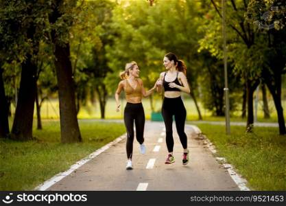 Two pretty young women running on a lane in the park