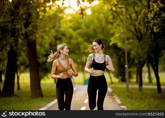 Two pretty young women running on a lane in the park