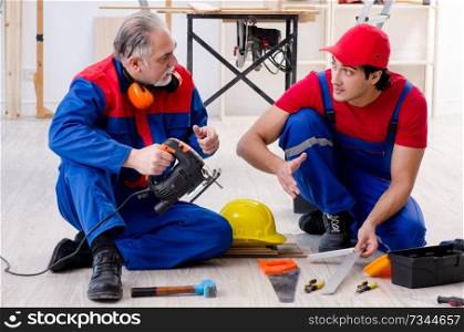 Two professional contractors laying flooring at home  