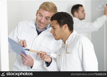 two professional factory painters workers looking documents