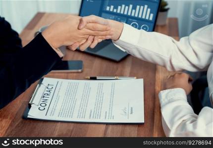 Two professionals successfully close business deal with closeup handshake, sealing the partnership agreement. Legal document and signature as formal agreement between the two companies. Enthusiastic. Closeup handshake in after successful business meeting. Enthusiastic