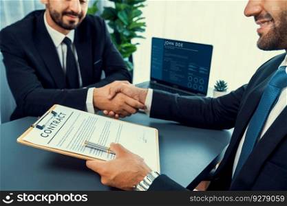 Two professionals successfully close business deal with closeup handshake, sealing the partnership agreement. Legal document and handshaking as formal agreement between two companies. Fervent. Closeup handshake in after successful business meeting. Fervent