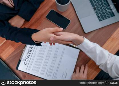 Two professionals successfully close business deal with closeup handshake, sealing the partnership agreement. Legal document and signature as formal agreement between the two companies. Enthusiastic. Closeup handshake in after successful business meeting. Enthusiastic