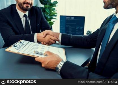 Two professionals successfully close business deal with closeup handshake, sealing the partnership agreement. Legal document and handshaking as formal agreement between two companies. Fervent. Closeup handshake in after successful business meeting. Fervent