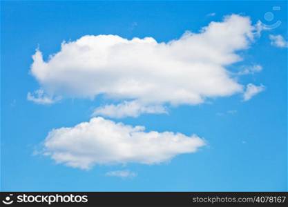 two puffy white clouds in blue summer sky