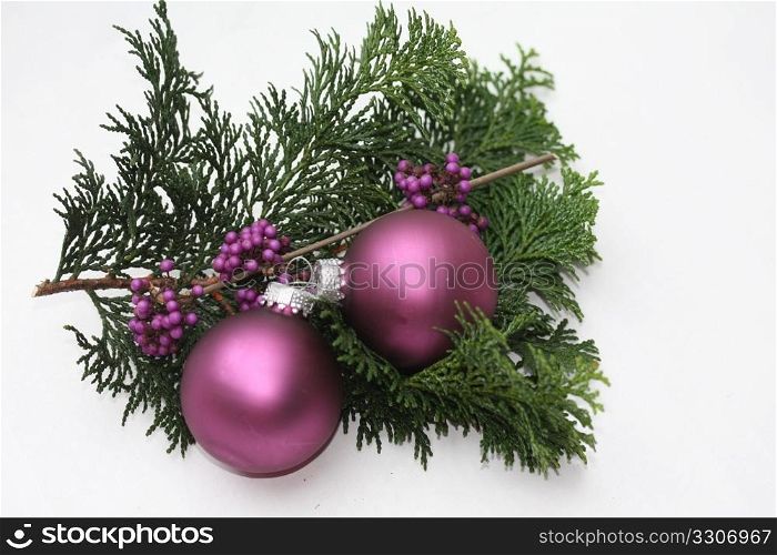 Two purple christmas balls and some purple berries