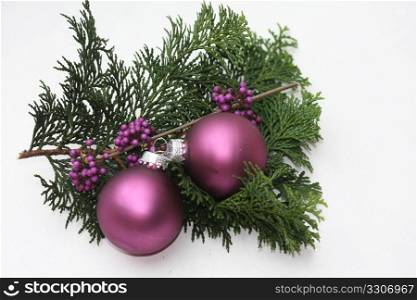 Two purple christmas balls and some purple berries