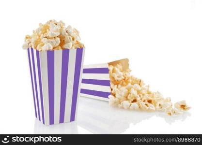 Two purple white striped carton buckets with tasty cheese popcorn, isolated on white background. Box with scattering of popcorn grains. Movies, cinema and entertainment concept.