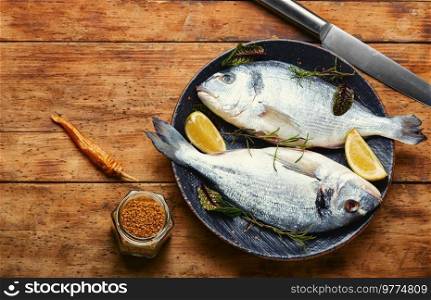Two raw dorado fish for cooking on a plate, dieting. Uncooked fish.Copy space. Fresh gilthead fish, space for text