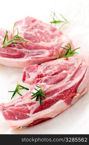 Two raw fresh lamb chops with rosemary herb