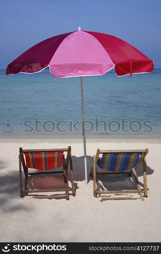 Two reclining chairs under a beach umbrella on the beach, Phi Phi Islands, Thailand