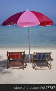 Two reclining chairs under a beach umbrella on the beach, Phi Phi Islands, Thailand