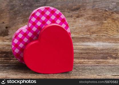 two red and pink hearts. pair of red and pink hearts laying together on wooden background