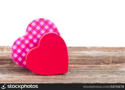 two red and pink hearts. pair of red and pink hearts laying together on wood border over white