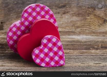 two red and pink hearts. three red and pink hearts laying together on wooden background