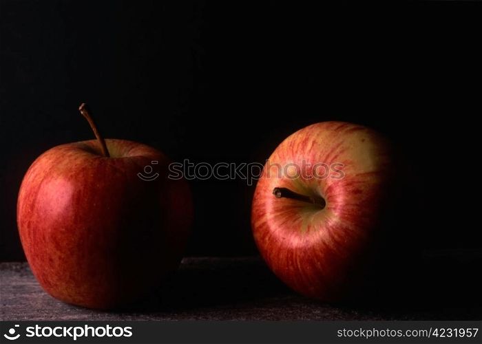 Two red apples isolated on black background