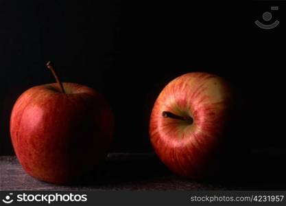 Two red apples isolated on black background
